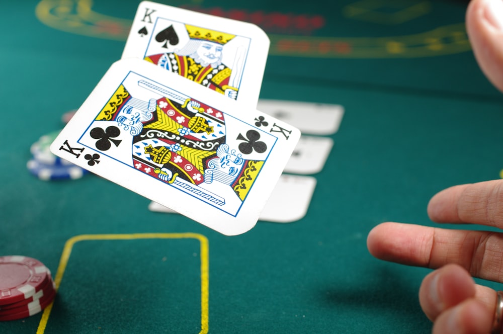 Seseorang bermain poker dengan tumpukan chip dan kartu — ilustrasi panduan poker Mpo007